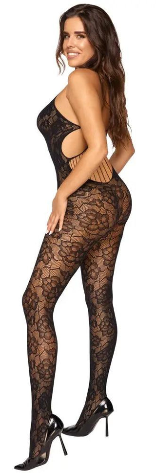 En person som bär Fantasy Catsuit, en svart spetsstrumpa med ett rygglöst stretchband, ler och poserar i profil med höga klackar.